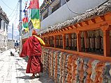 208 Monk Spins Prayer Wheels Near Northern End Of Kagbeni There is a long prayer wheel wall approaching the northern end of Kagbeni, with the restricted region of Upper Mustang beyond.